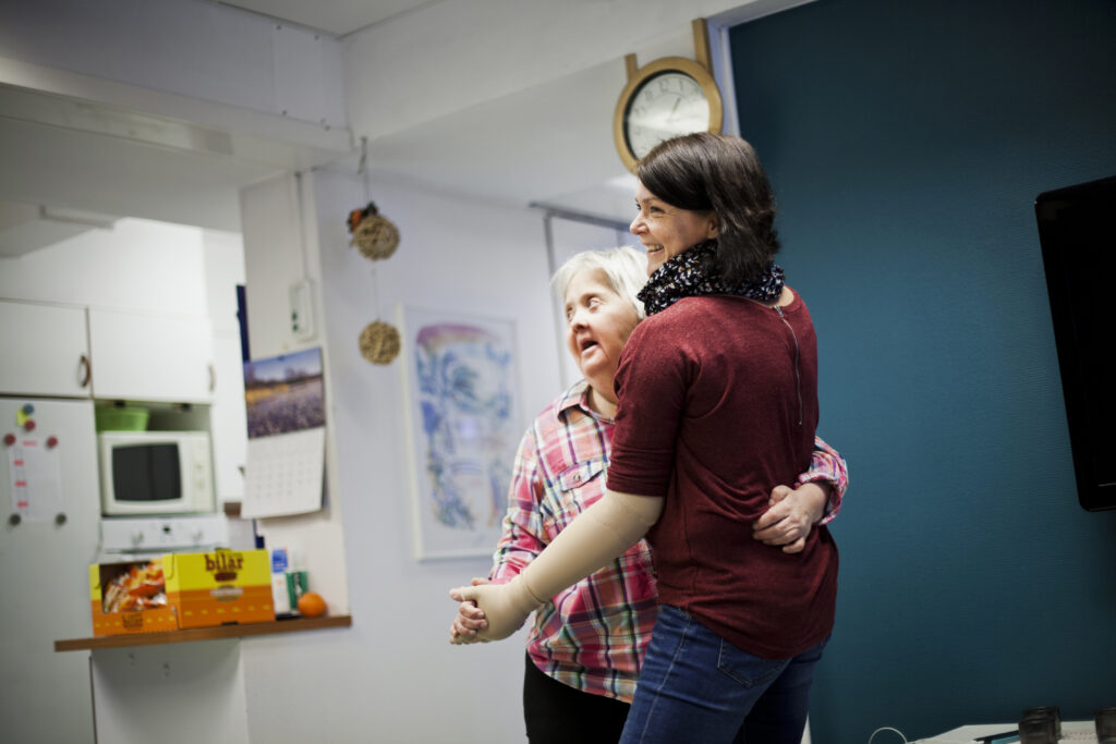 Mentally challenged woman dancing with caregiver at home